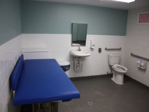large washroom, change table with sink, toilet and change table