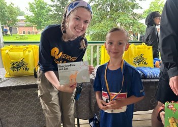 young boy with medal posing with RPZ staff and his prize