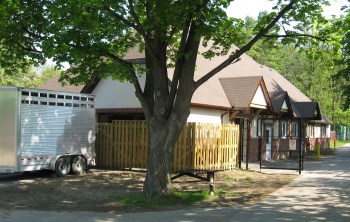 building amongst trees with animal trailer to the side